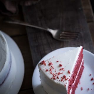 Moist Red Velvet Cake and Whipped Cream Cheese Frosting served on a white plate