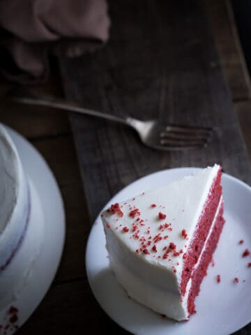 Moist Red Velvet Cake and Whipped Cream Cheese Frosting served on a white plate