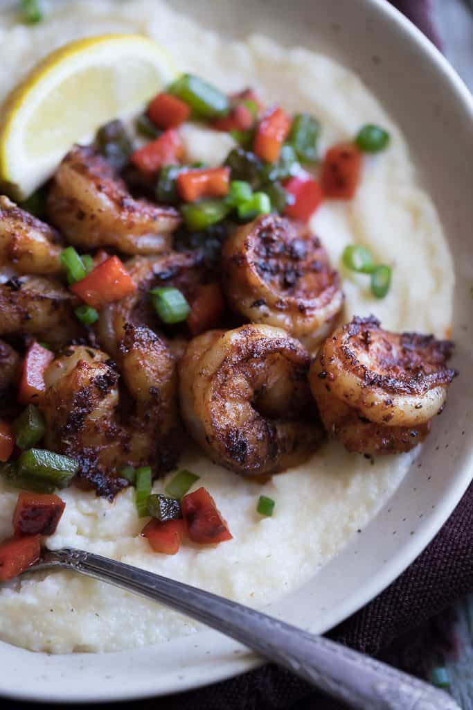 Closeup on the Homemade Cajun Shrimp and Grits served with mashed potatoes and a piece of lemon on top