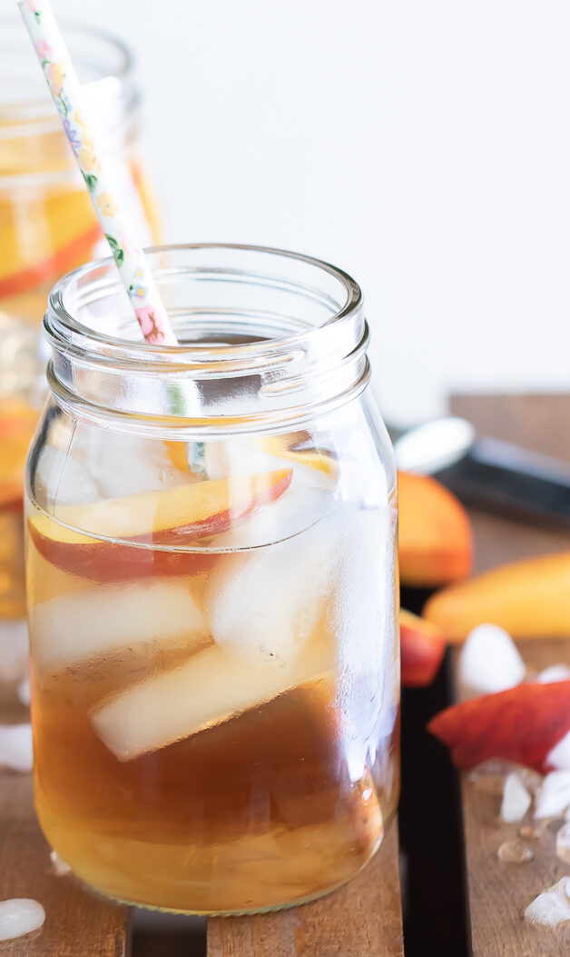 Georgia Peach Cocktail served in two glass jars with straws inside each jar