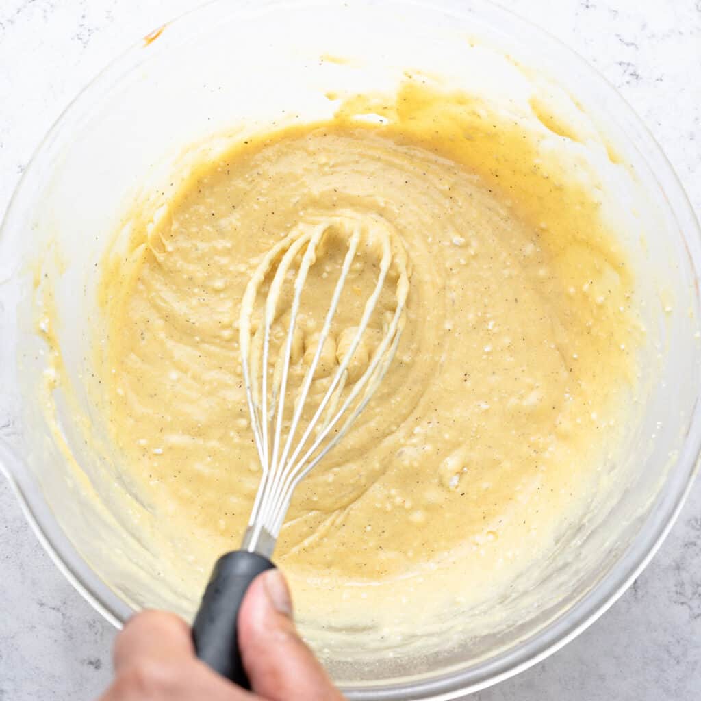 Mixing the cake batter well with a whisk held in a left hand