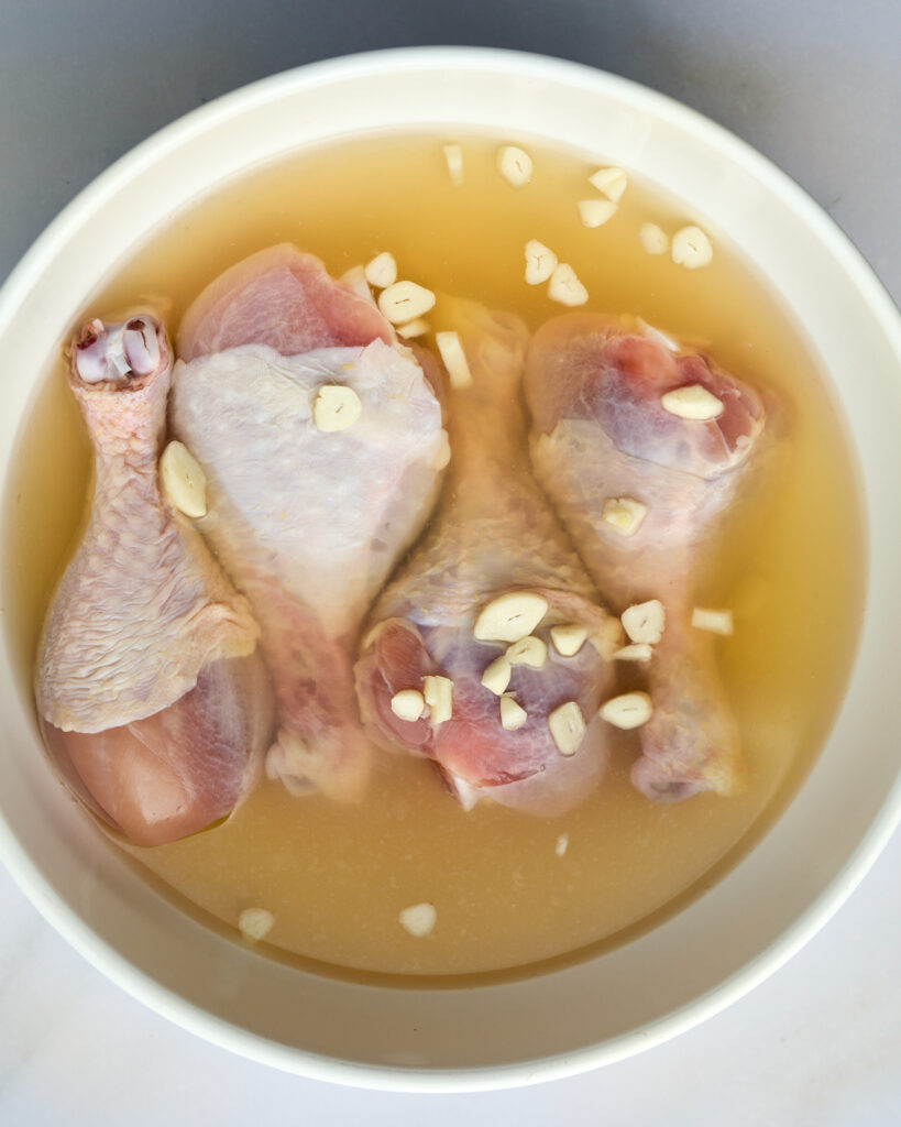 Chicken in brine marinade in bowl. 