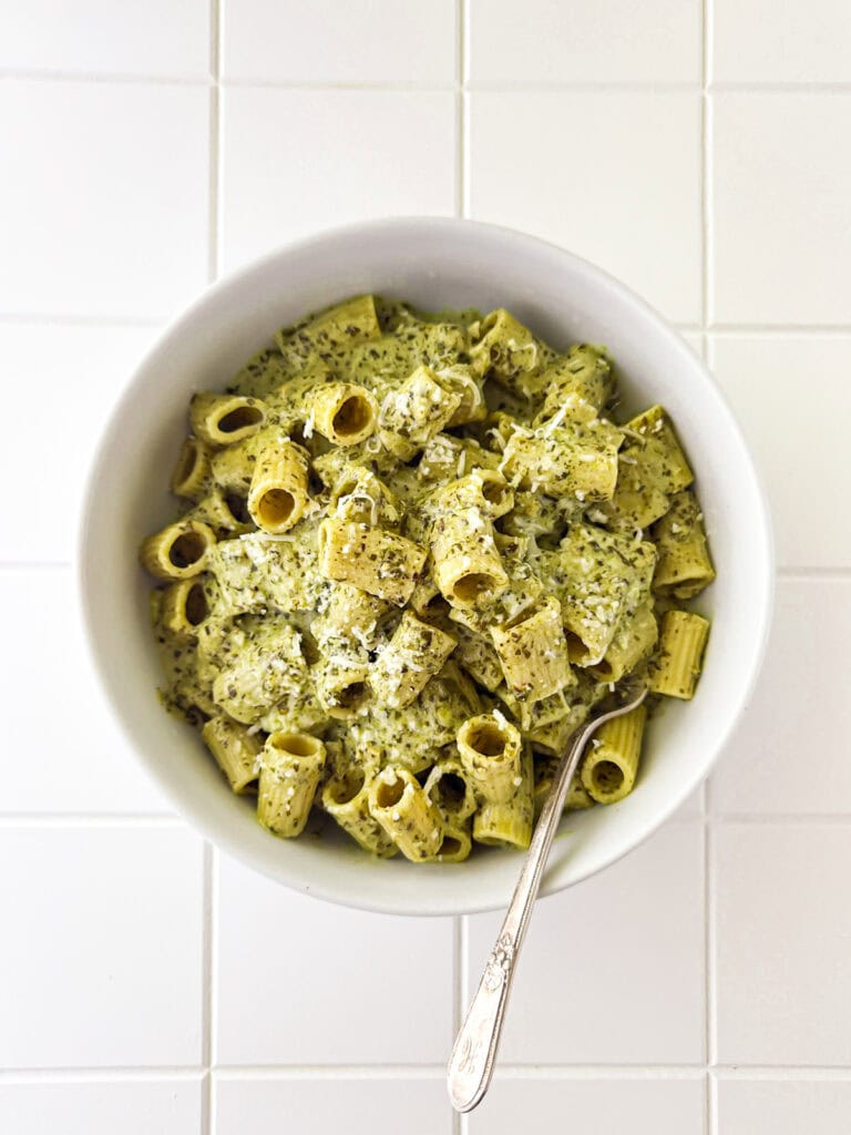 Creamy Pesto Pasta in white bowl on white table top