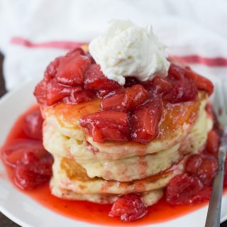 Closeup of the delicious Fluffy Champagne Strawberry Glazed Pancakes served in a white plate
