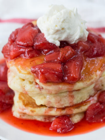 Pancakes with Strawberry Glaze served in a white plate