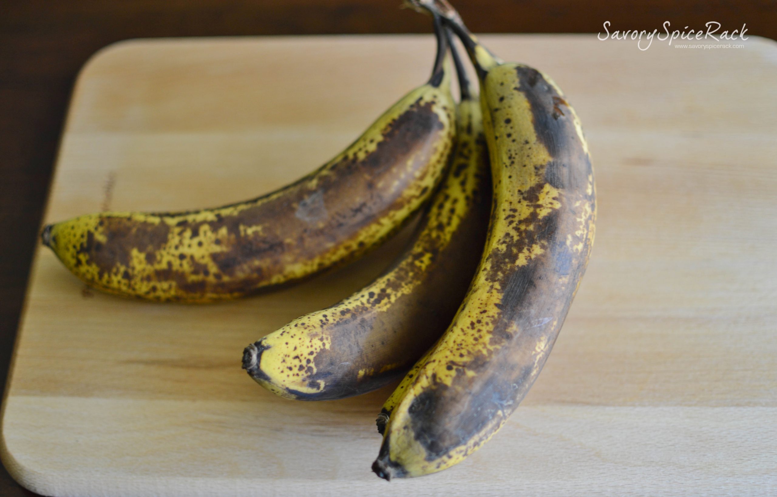 Three perfectly overripe bananas on a wooden board