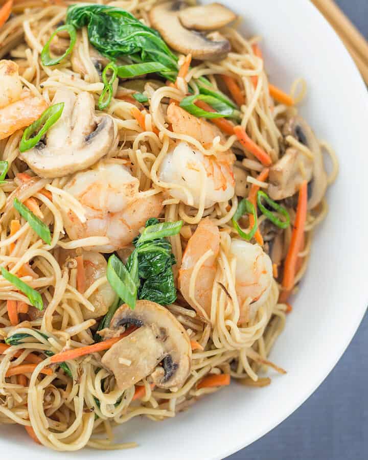 Easy Stir Fried Chinese Noodles with Shrimp in a white bowl with chopsticks on the side