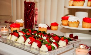 Cheap trick. Our theme colors were red, white, and pink. This was chosen because Valentine's day was before our party. This helped us to purchase cheap treats that matched our colors. Premade cupcakes that can be bought in bulk from Sam's club helped save time and money. I believe the cupcakes only cost $15 for 30 cupcakes. Also buying containers like the glass vases and cupcake tower are reusable for other parties.