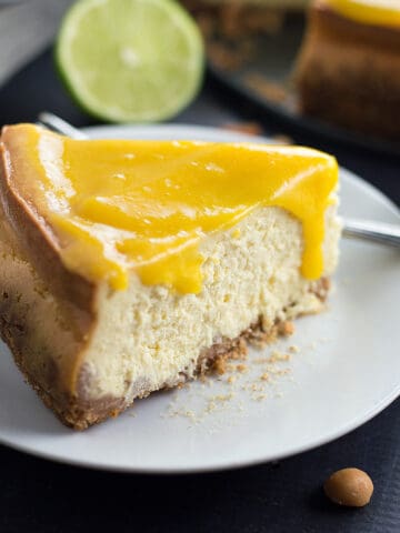 Closeup on the delicious Mango Cheesecake with Macadamia Nut Crust with a piece of lime blurred in the background