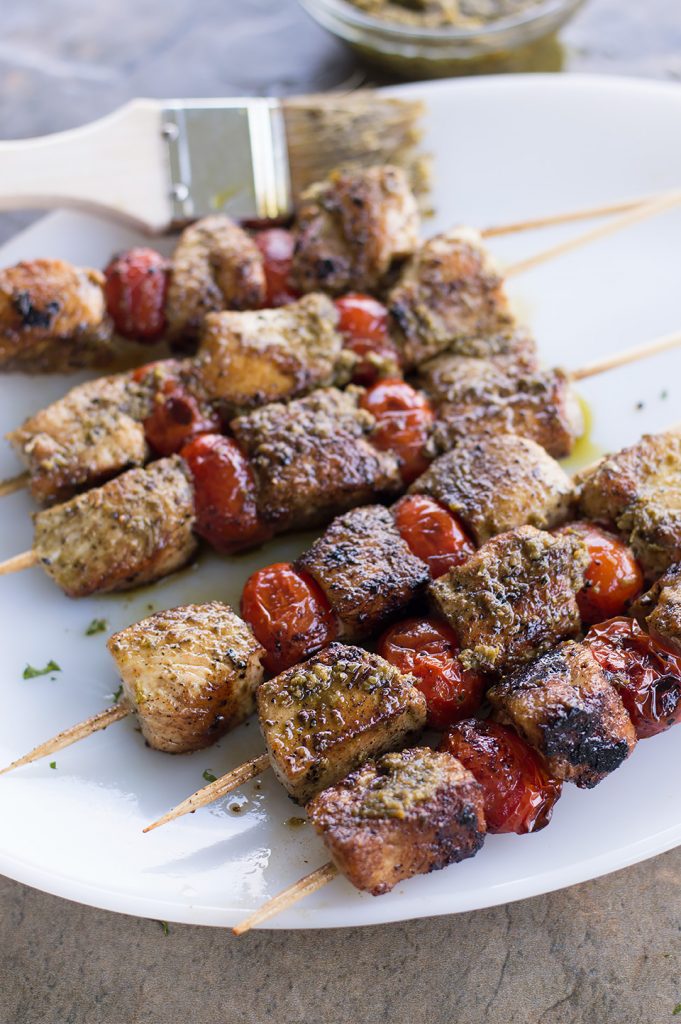 Greek Chicken Skewers With Pesto Sauce on plate with marinade brush