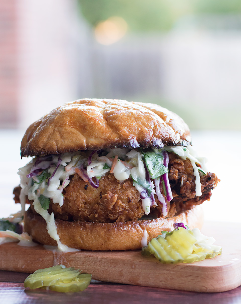 Sideview of the mouthwatering Buttermilk Fried Chicken Sandwich with Cilantro Jalapeño Coleslaw