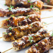 Apricot and Ginger Glazed Chicken Skewers on plate with spoon.