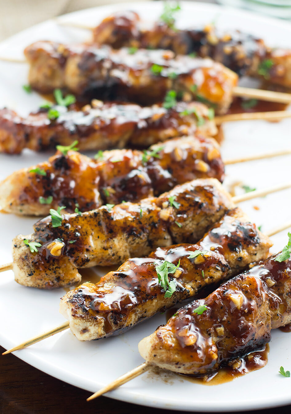 Apricot and Ginger Glazed Chicken Skewers on plate with spoon.
