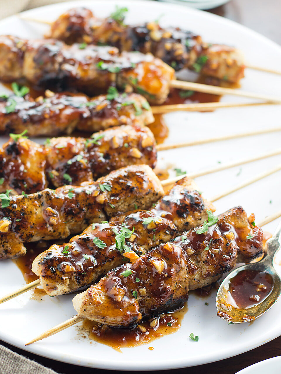 Apricot and Ginger Glazed Chicken Skewers on plate with spoon.