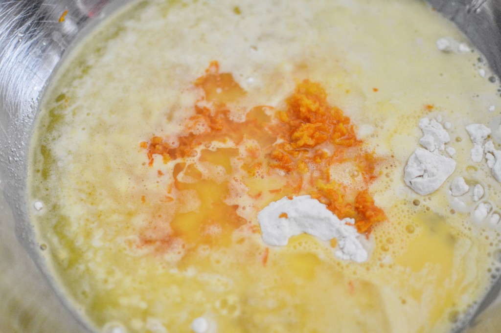 Adding the orange juice, melted butter, eggs, and vanilla to the mixing bowl