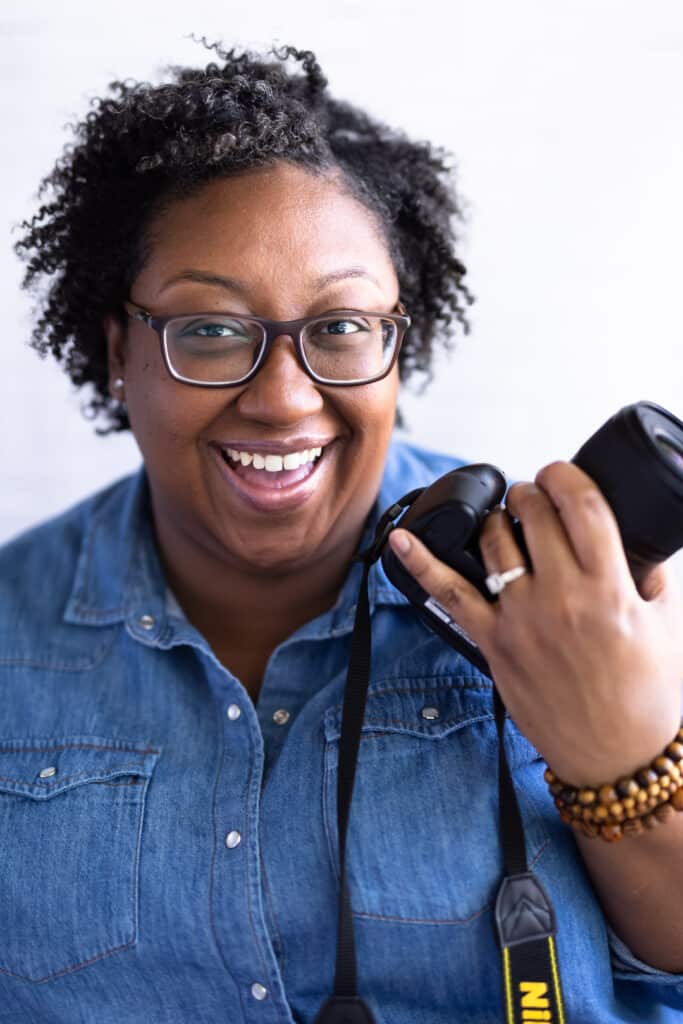 Female wearing blue shirt on holding camera. 