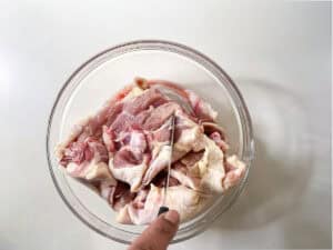 Raw Chicken In Glass Bowl Being Scored