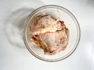 Berbere Seasoned Uncooked Chicken Thighs In Glass