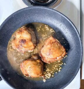 Browned Chicken Thighs With Sauce In Pan