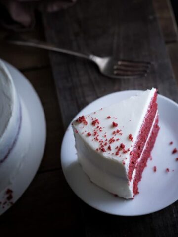 Moist Red Velvet Cake and Whipped Cream Cheese Frosting served on a white plate
