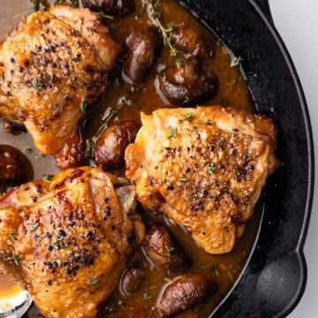 Cooked chicken in mushroom sauce in cast iron pan