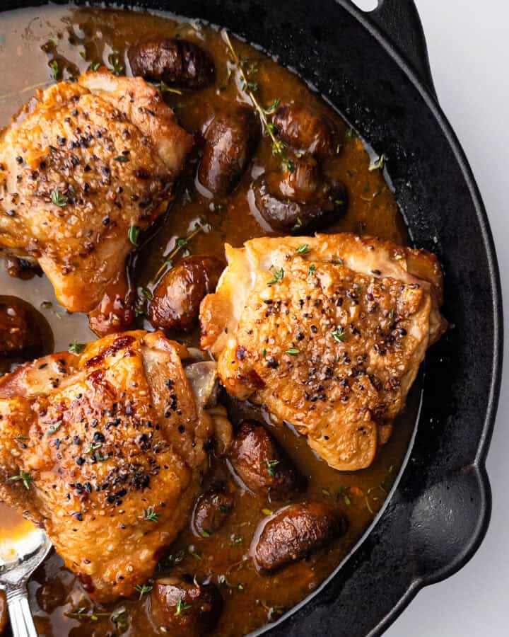 Cooked chicken in mushroom sauce in cast iron pan