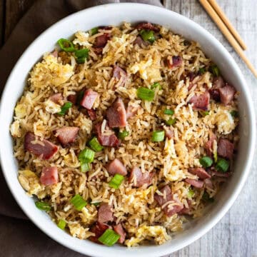 ham fried rice in white bowl with chopsticks on wooden table