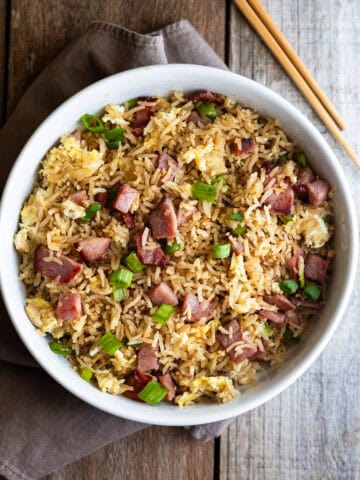 ham fried rice in white bowl with chopsticks on wooden table