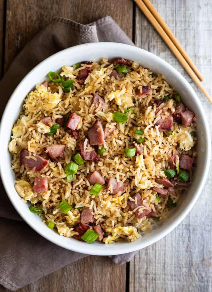 ham fried rice in white bowl with chopsticks on wooden table
