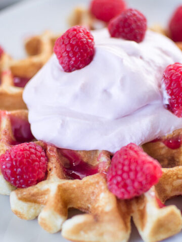Buttermilk Waffles with Raspberry Champagne Mascarpone Cream served on a white plate