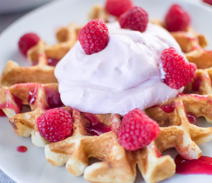 Buttermilk Waffles with Raspberry Champagne Mascarpone Cream served on a white plate