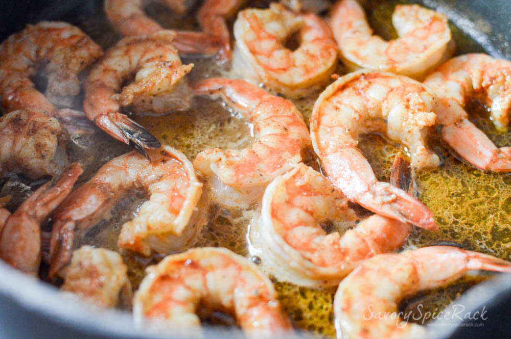 Shrimp getting cooked in oil inside a pan