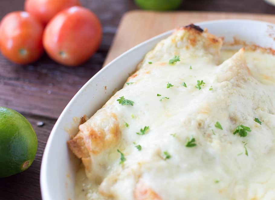 Closeup on the delicious White Sauce Enchiladas with Salsa Verde served in a white plate