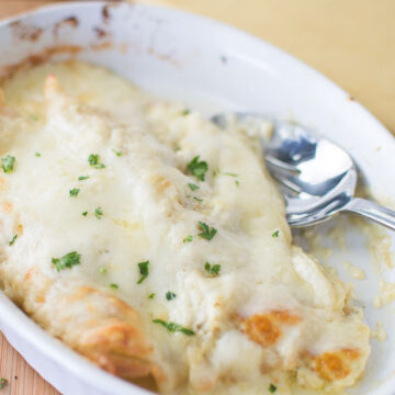 white sauce enchiladas in white dish with spoon