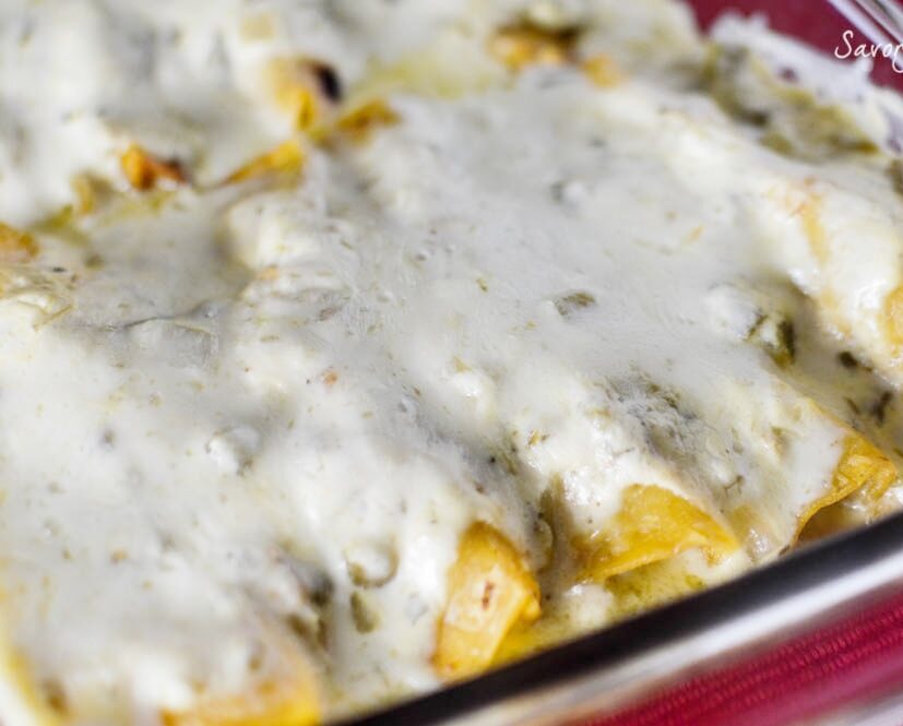 chicken enchiladas with white sauce in glass pan