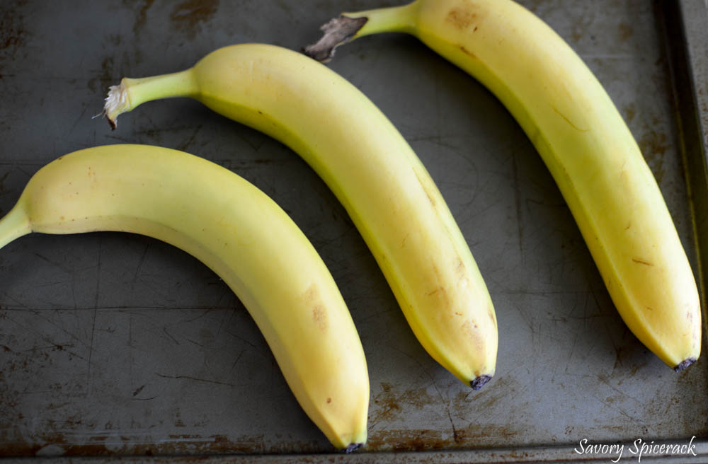 Three fresh bananas on a metal tray